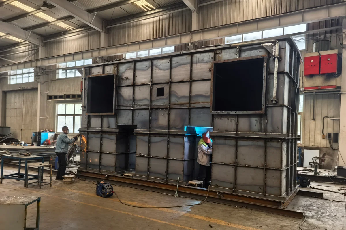 大型钢制箱体制造车间内同时进行焊接和打磨作业